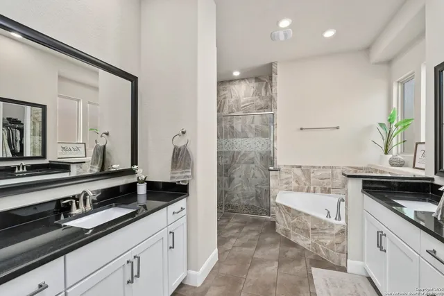 a large white kitchen with a granite countertop sink and white cabinets