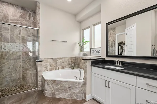 a bathroom with a granite countertop sink a mirror and shower