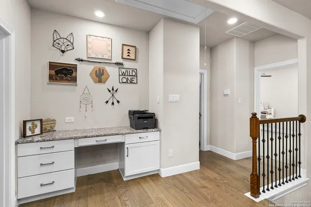 a hall with kitchen island white cabinets and white appliances