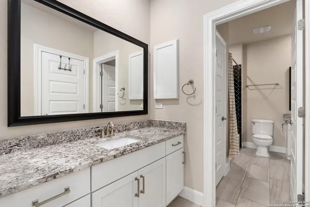 a bathroom with a granite countertop sink and a mirror