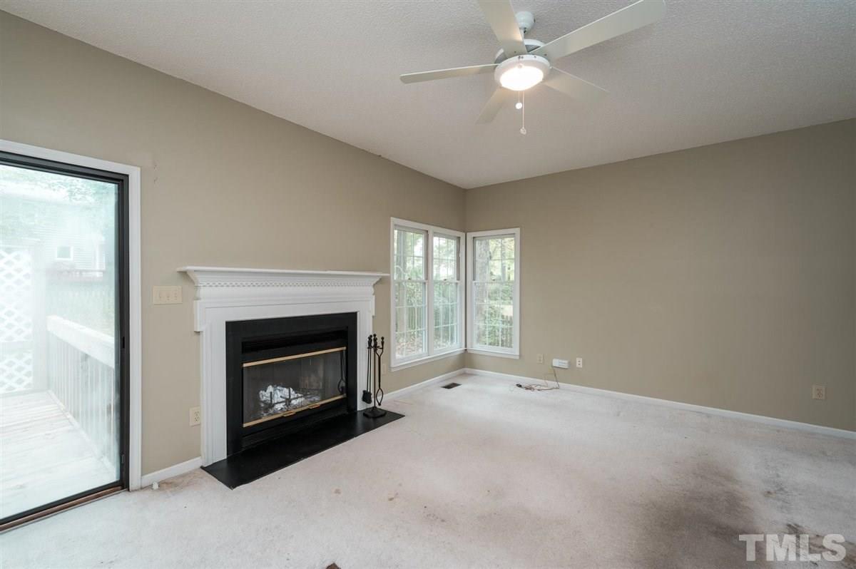 5617 Barham Court Raleigh, NC 27613 - Photo 13 of 30 a living room with furniture a fireplace and a ceiling fan