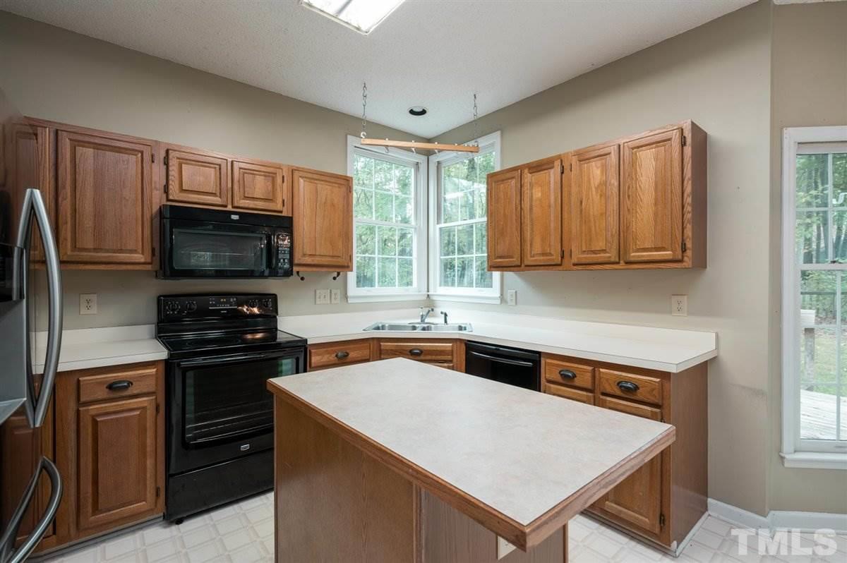 5617 Barham Court Raleigh, NC 27613 - Photo 16 of 30 a kitchen with stainless steel appliances a stove microwave and refrigerator