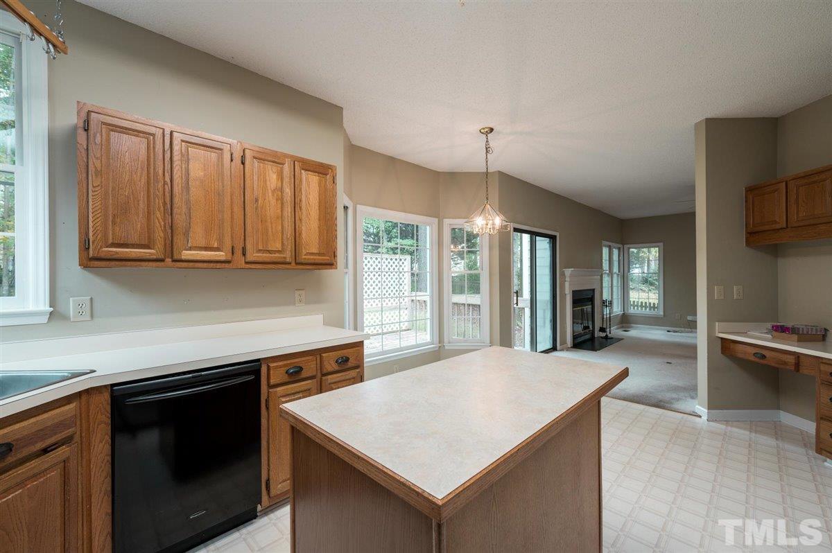 5617 Barham Court Raleigh, NC 27613 - Photo 19 of 30 a kitchen with a stove a sink dishwasher and a refrigerator with wooden floor