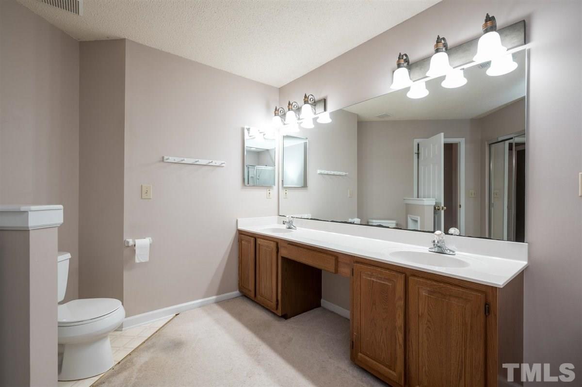 5617 Barham Court Raleigh, NC 27613 - Photo 24 of 30 a bathroom with a sink a toilet and a mirror
