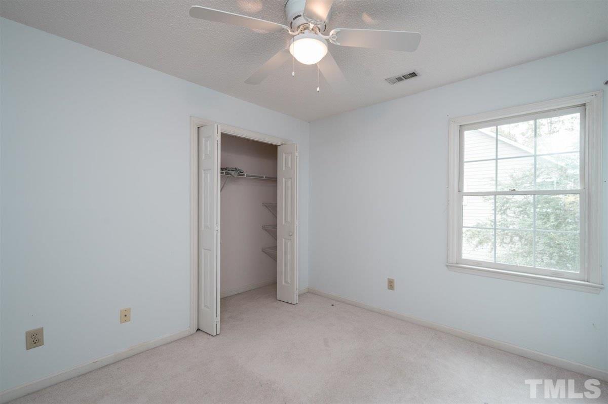 5617 Barham Court Raleigh, NC 27613 - Photo 27 of 30 an empty room with a ceiling fan and a window