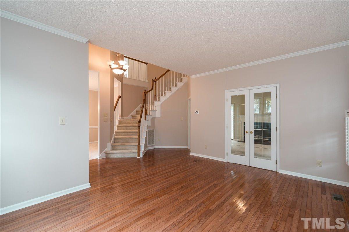 5617 Barham Court Raleigh, NC 27613 - Photo 10 of 30 a view of an empty room with wooden floor and stairs