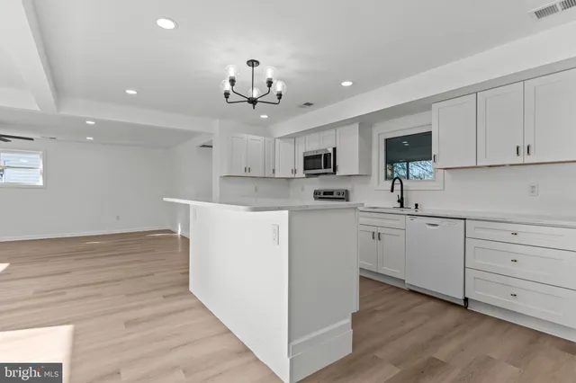 a kitchen with kitchen island white cabinets and white appliances