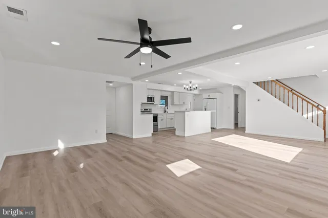 a view of empty room with wooden floor and window