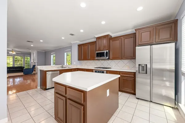 a kitchen with stainless steel appliances granite countertop a refrigerator a sink and a stove