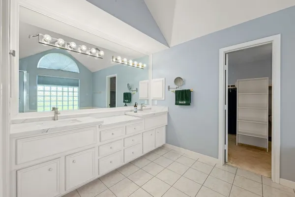 a spacious en suite bathroom with a double vanity sink and a mirror