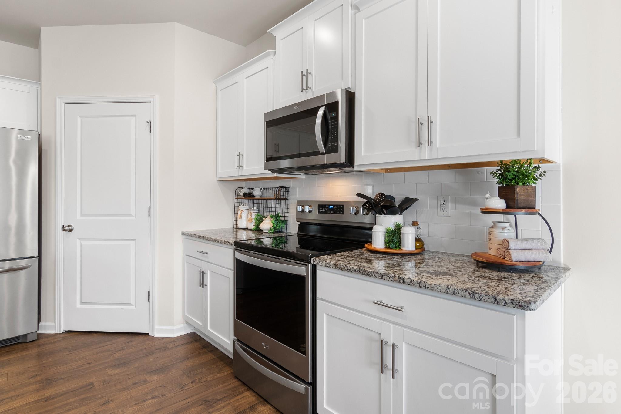 744 Saddlebred Lane Locust, NC 28097 - Photo 11 of 47 a kitchen with granite countertop white cabinets and stainless steel appliances