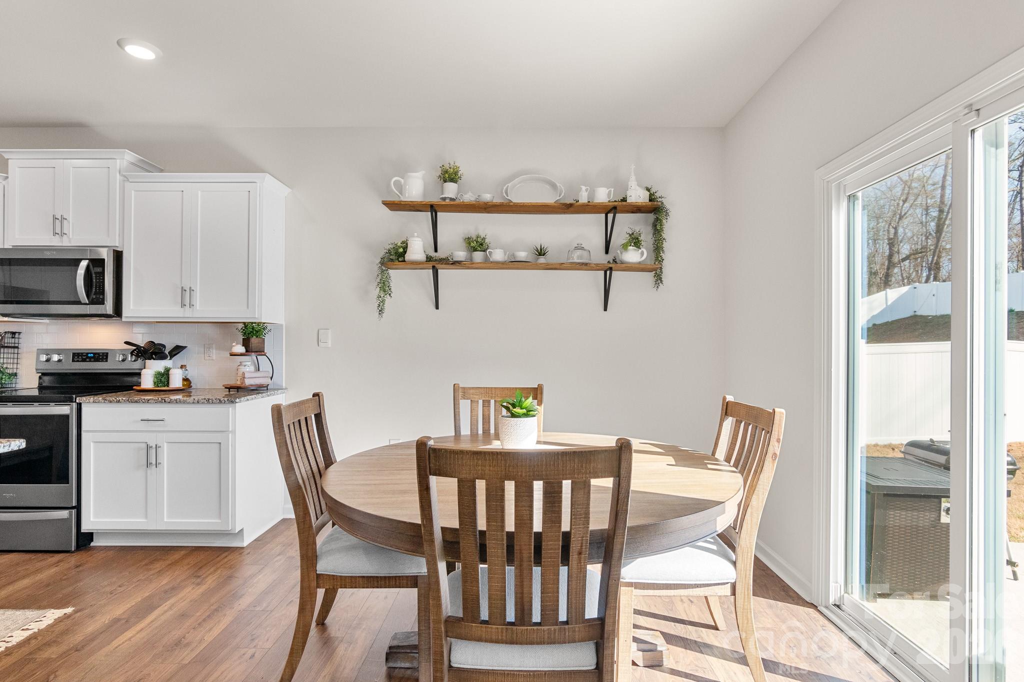 744 Saddlebred Lane Locust, NC 28097 - Photo 13 of 47 a view of a dining room with furniture and wooden floor