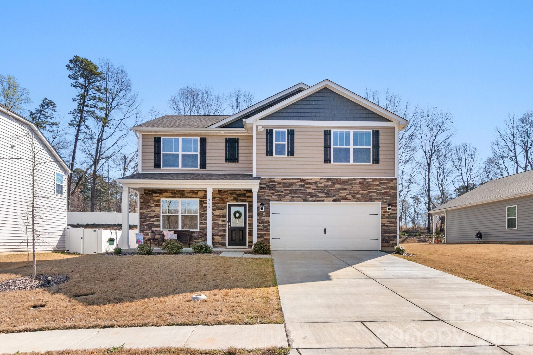744 Saddlebred Lane Locust, NC 28097 - Photo 2 of 47 a front view of a house with a yard and garage