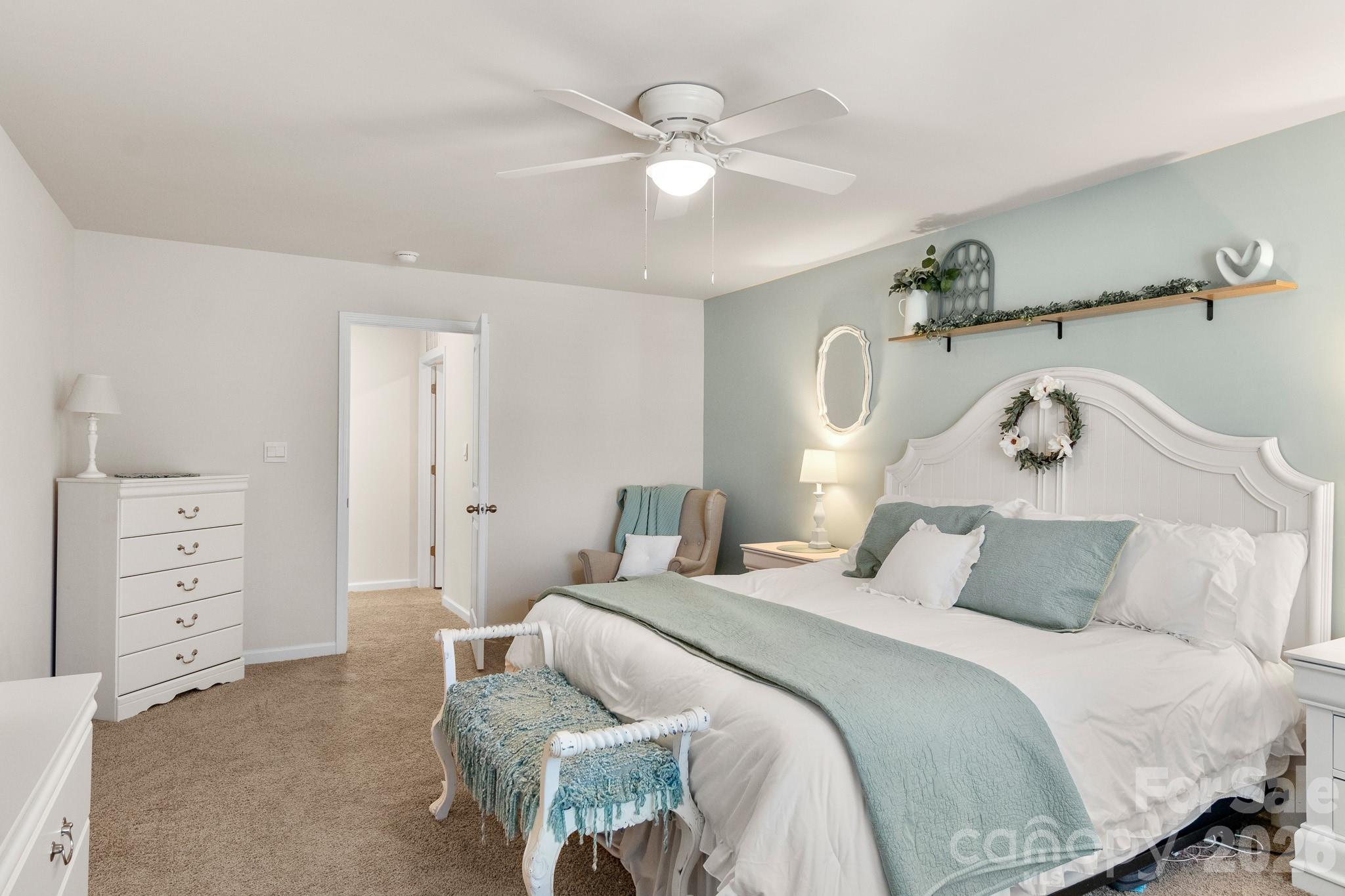 744 Saddlebred Lane Locust, NC 28097 - Photo 25 of 47 a bedroom with a bed and a chandelier