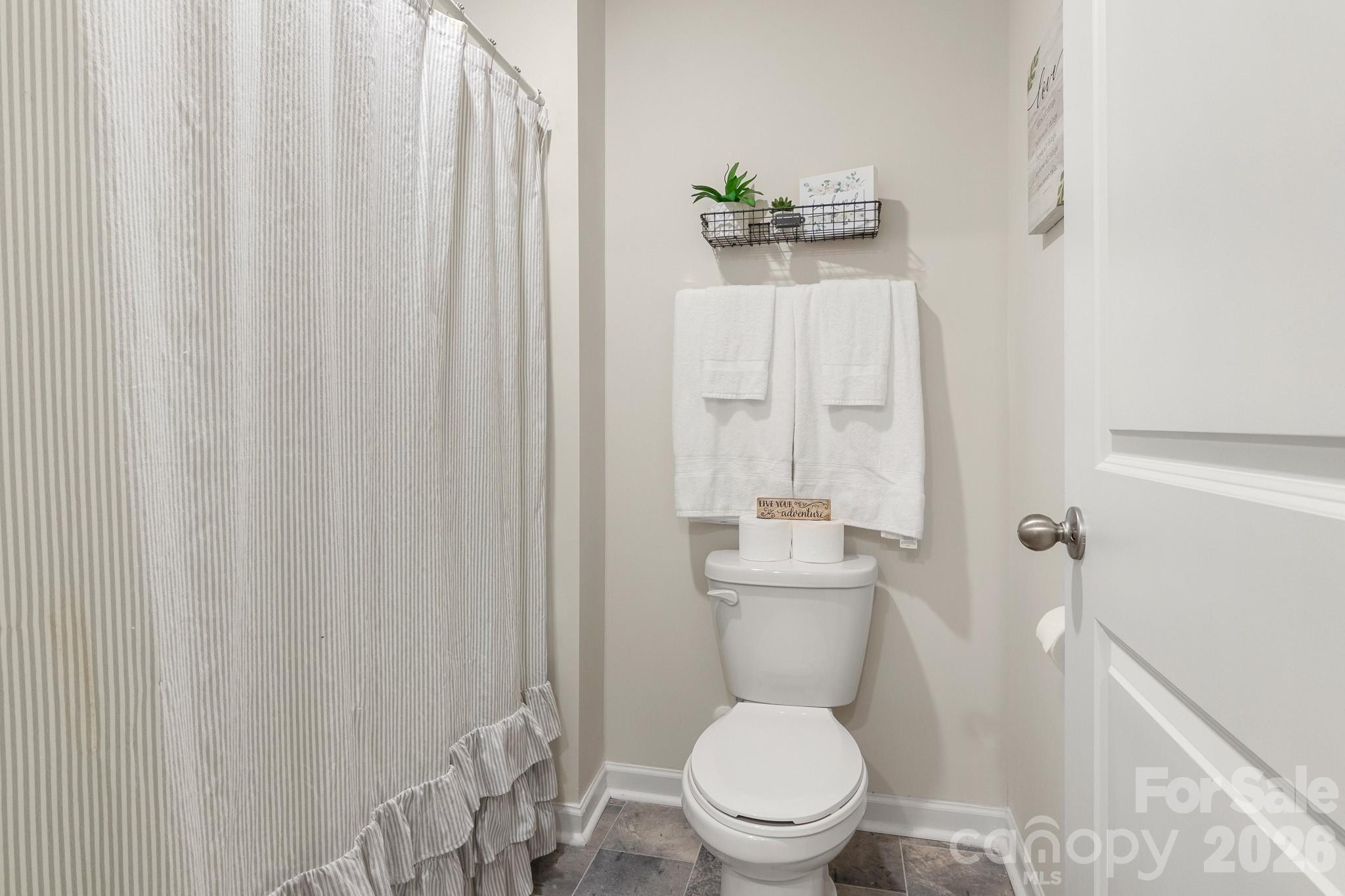 744 Saddlebred Lane Locust, NC 28097 - Photo 41 of 47 a white toilet sitting next to a shower curtain