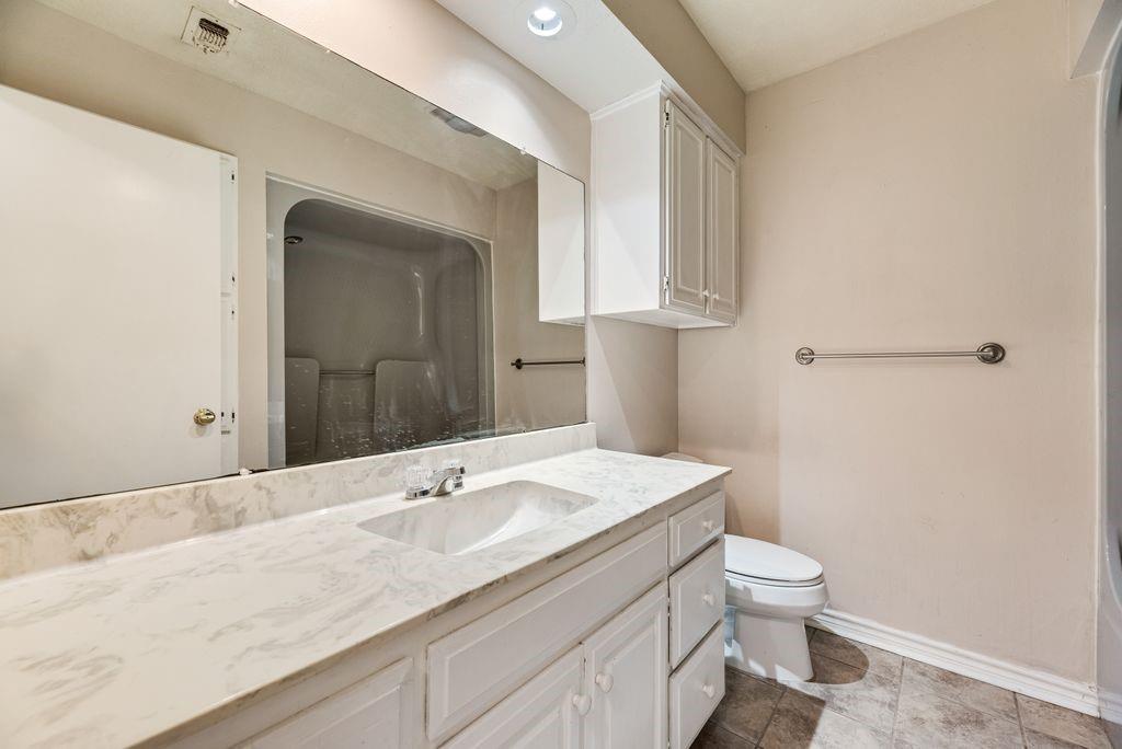 298 Butterfield Road Denison, TX 75021 - Photo 13 of 34 Bathroom featuring a white vanity with an integrated sink, a large wall-mounted mirror, overhead recessed lighting, and a white toilet