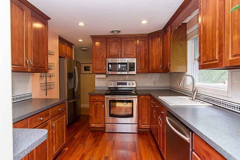 88 Selwyn Road Newton, MA 02461 - Photo 5 of 26 a kitchen with stainless steel appliances granite countertop wooden cabinets a stove a sink and a center island
