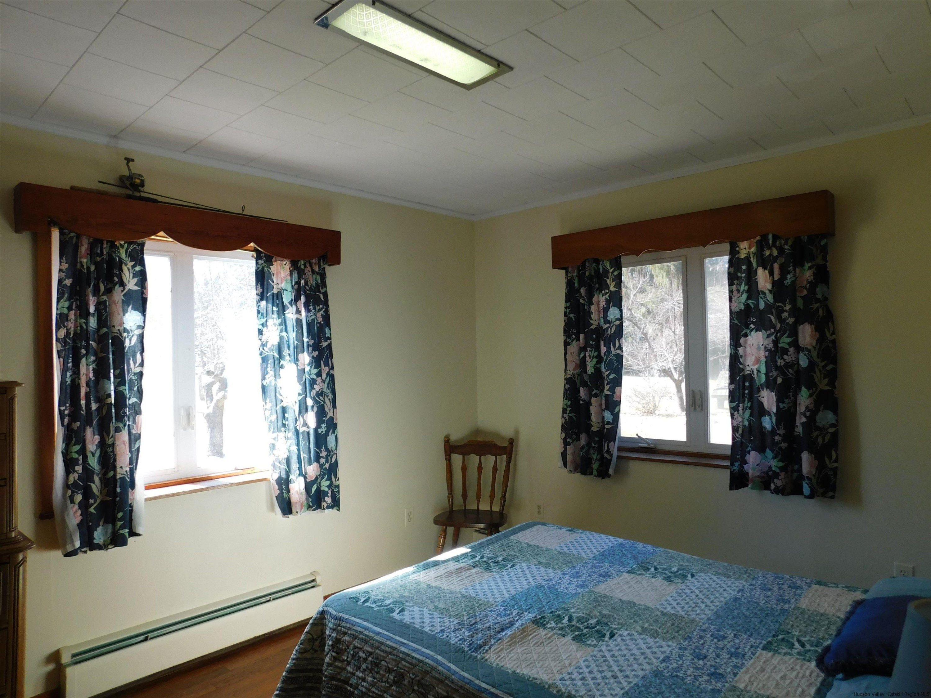 145 Sportsman Road Napanoch, NY 12458 - Photo 9 of 31 a bedroom with a bed window and chandelier