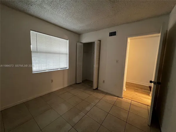 an empty room with windows and closet
