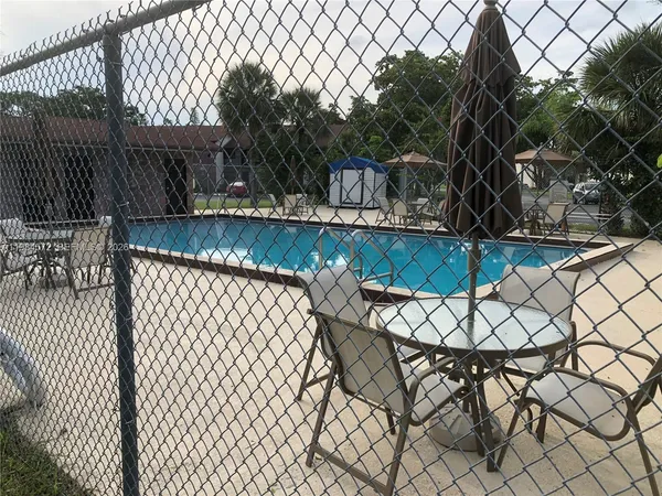 a view of a patio with table and chairs with wooden fence