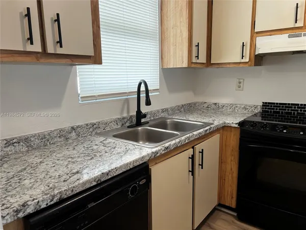a kitchen with granite countertop a sink and cabinets