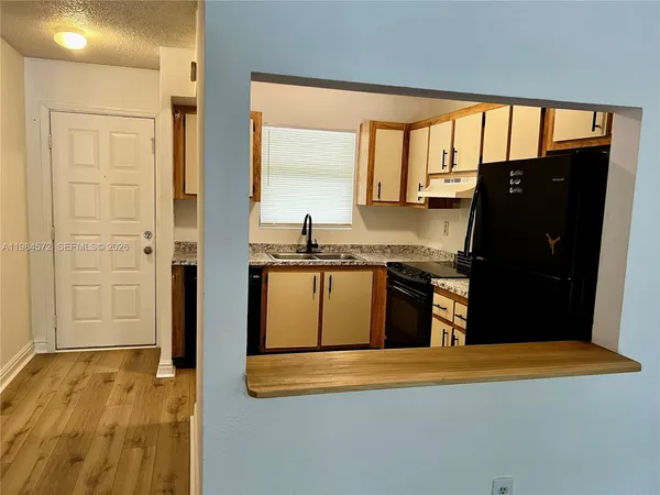 a kitchen with stainless steel appliances granite countertop a refrigerator and a stove