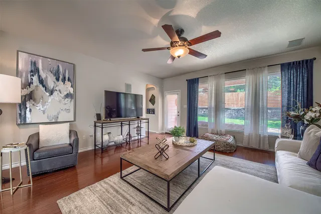a living room with furniture a flat screen tv and a large window