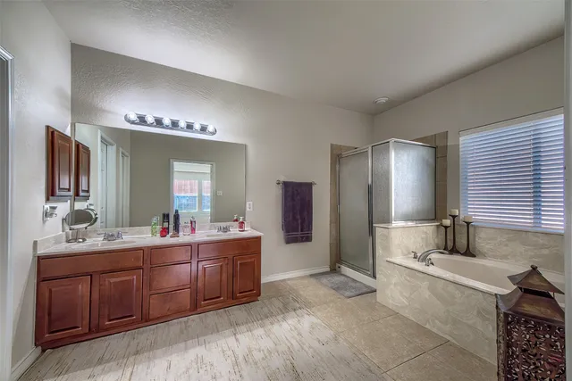a spacious bathroom with a granite countertop sink mirror and bathtub