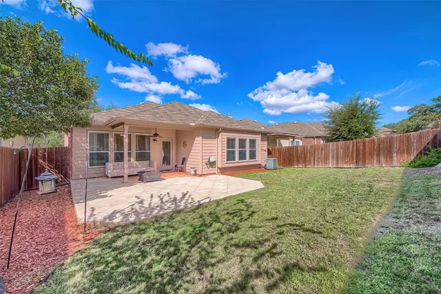 a view of a house with backyard and sitting area