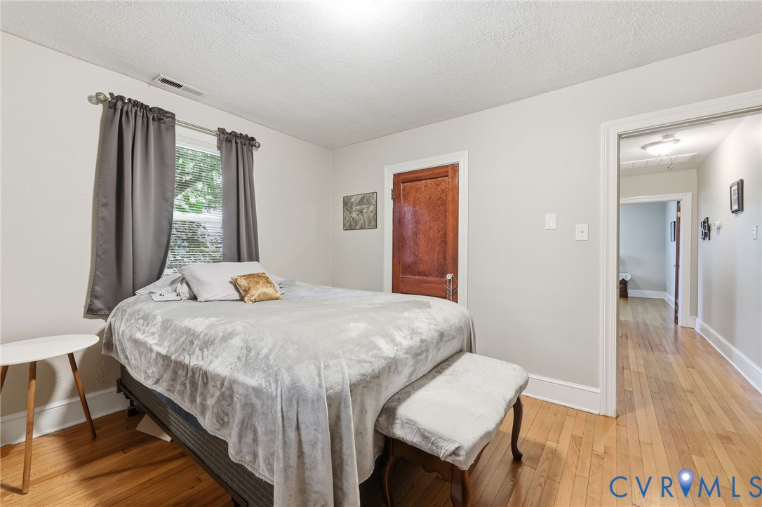 3510 East River Road Petersburg, VA 23803 - Photo 18 of 21 a bedroom with a bed and a table in it with wooden floor