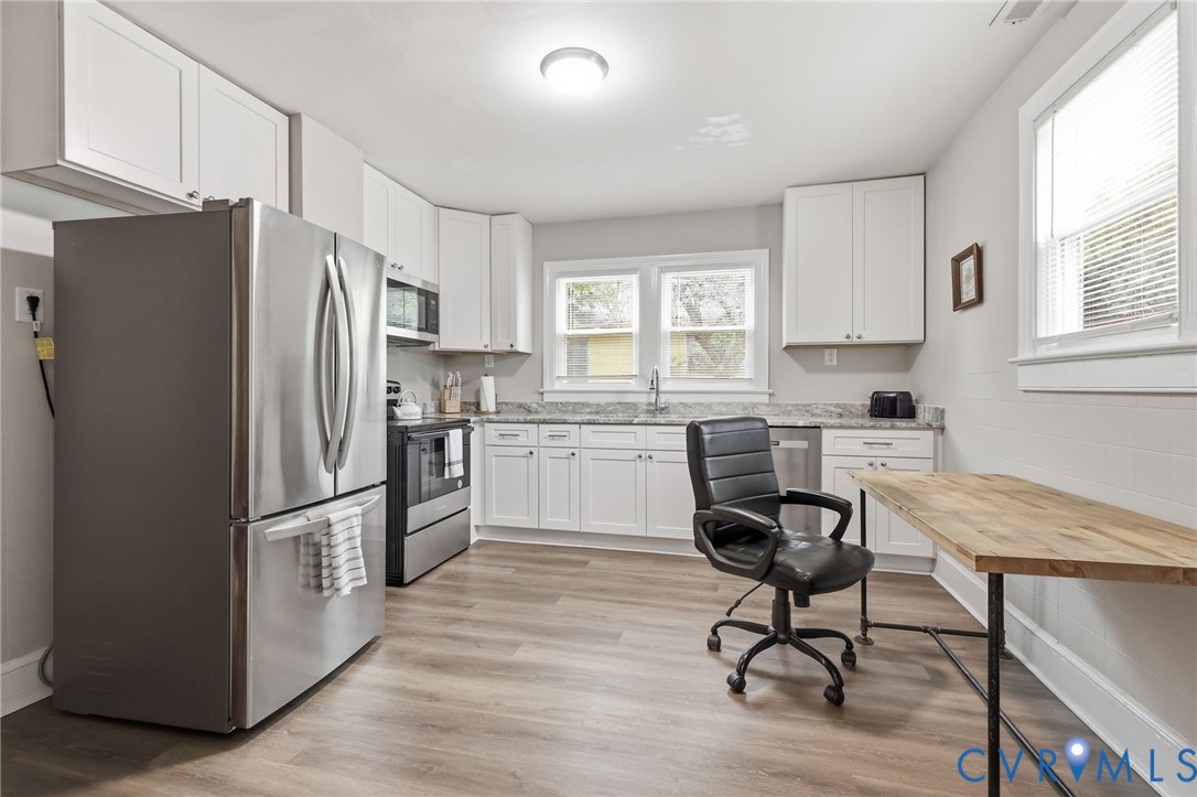 3510 East River Road Petersburg, VA 23803 - Photo 8 of 21 a kitchen with stainless steel appliances a refrigerator a stove a sink cabinets and a dining table