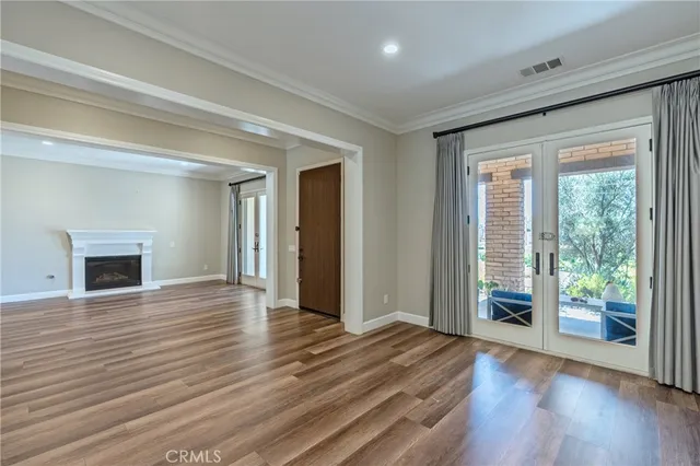 a view of empty room with wooden floor and fireplace