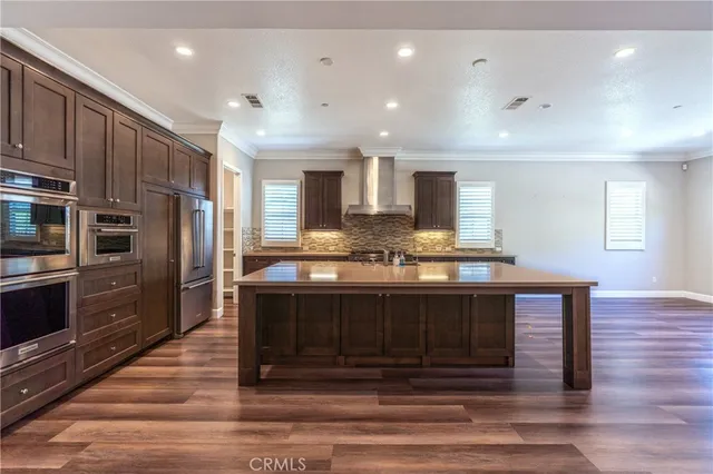 a kitchen with stainless steel appliances granite countertop a sink and wooden cabinets