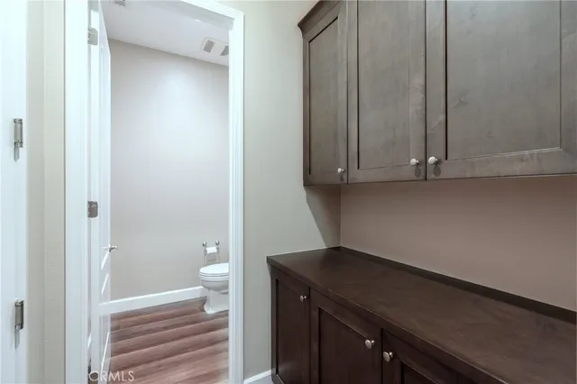 an empty room with wooden floor fireplace and windows