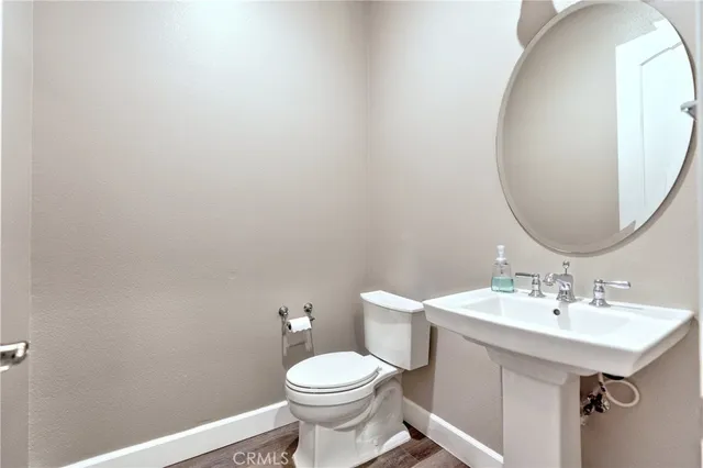 a view of an empty room with wooden floor fireplace and a window