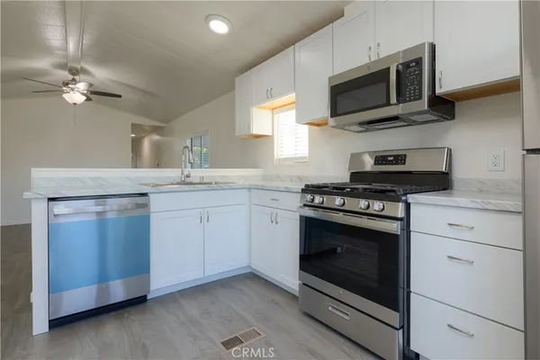 a kitchen with stainless steel appliances granite countertop a stove microwave and sink