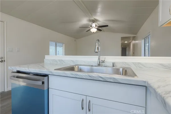 a bathroom with a granite countertop sink a light fixture and a mirror