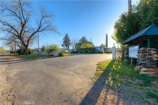 a view of a street with a building and trees in the background