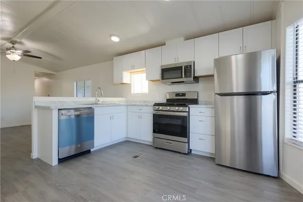 a kitchen with stainless steel appliances a refrigerator stove and white cabinets