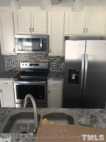 a kitchen with a refrigerator a stove a sink and a stove