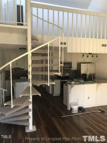 a kitchen with kitchen island granite countertop a stove a sink and a microwave