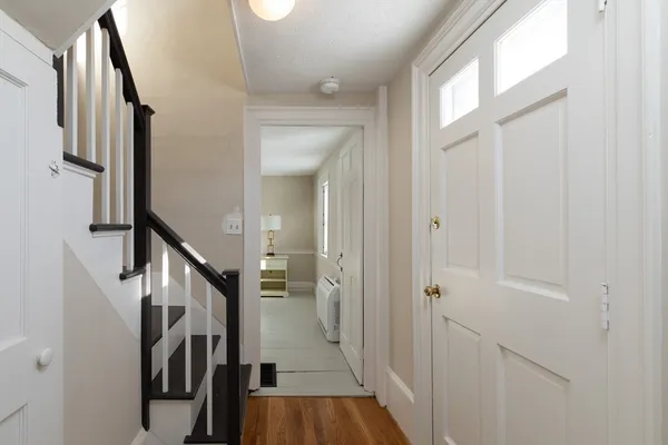 a view of hallway with stairs and wooden floor