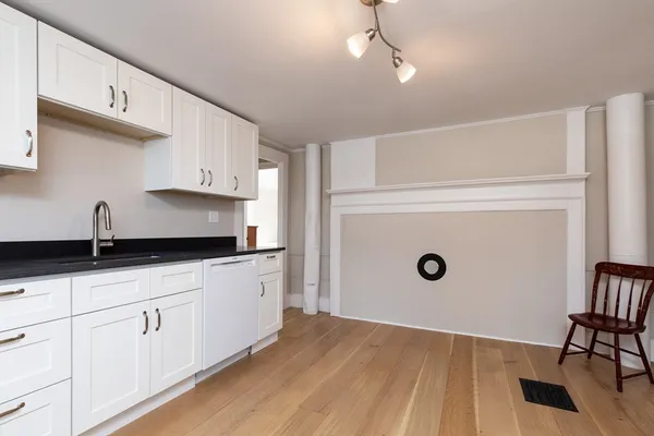 a kitchen with granite countertop a sink a stove and cabinets