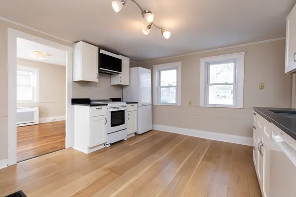 a kitchen with granite countertop a stove top oven and cabinets