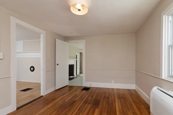 a view of a room with wooden floor and a window