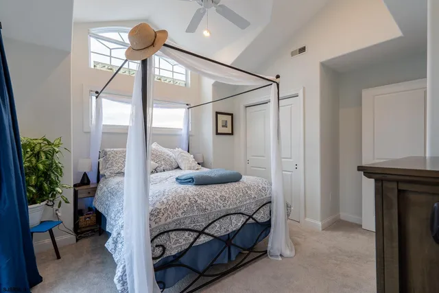 a bedroom with a bed and a large mirror on the dresser