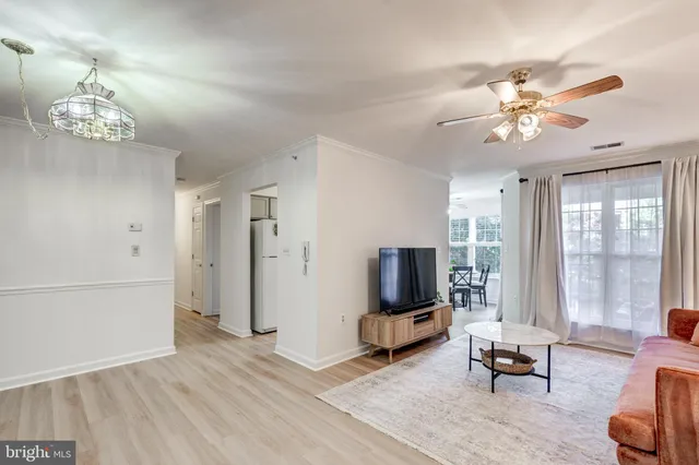 a living room with furniture chandelier and a flat screen tv