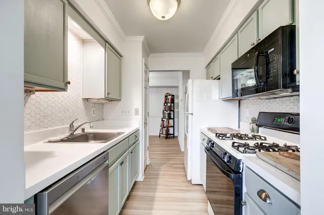 a kitchen with stainless steel appliances a stove a sink and a microwave