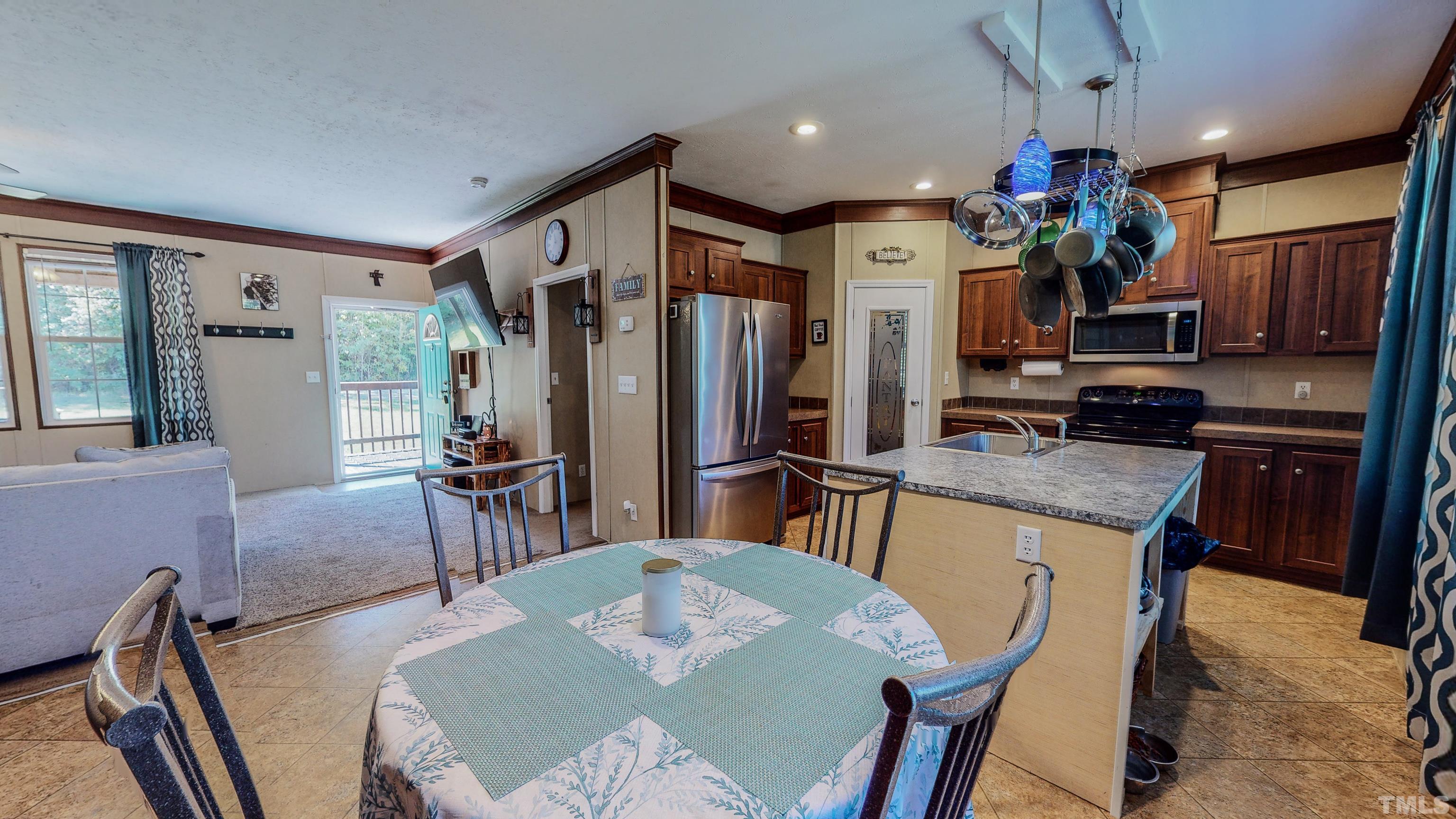 348 Wilbourne Run Roxboro, NC 27574 - Photo 14 of 25 a kitchen with granite countertop a refrigerator a stove a sink dishwasher a dining table and chairs with wooden floor