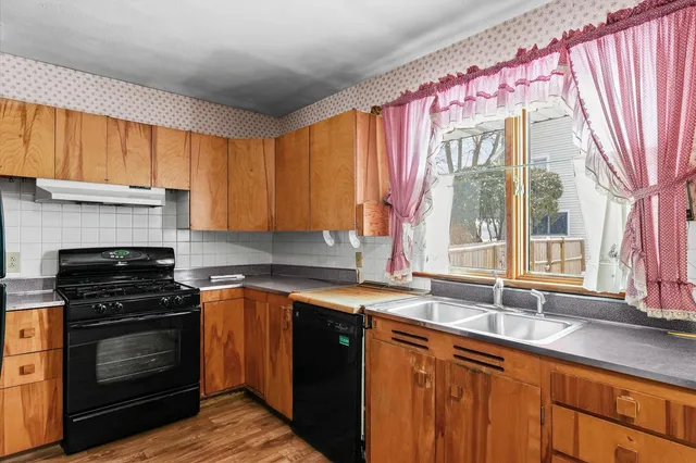 a kitchen with a sink stove top oven and cabinets